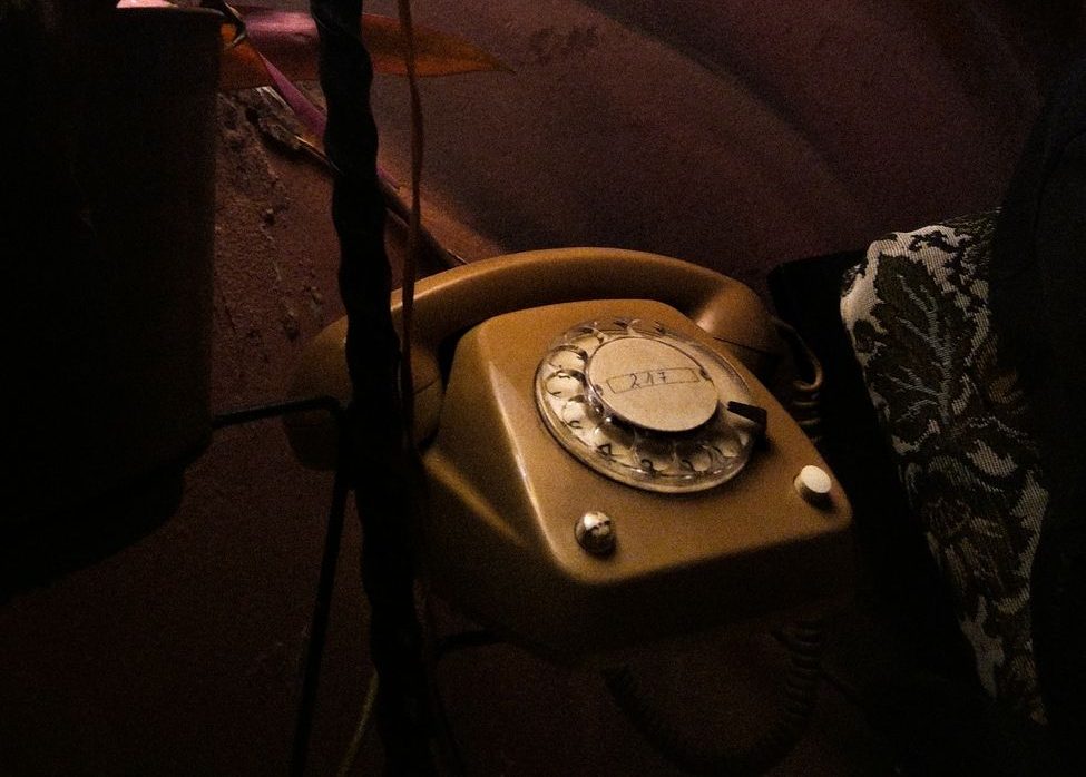 a old vintage telephone beside a lamp